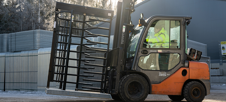 Truck som flytter en rotasjonsgrind med byggegjerder i bakgrunn